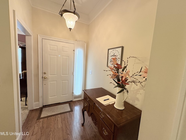 foyer featuring dark wood-style floors and crown molding