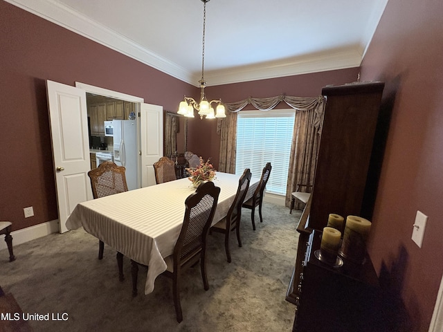 dining room with crown molding, baseboards, a notable chandelier, and carpet flooring