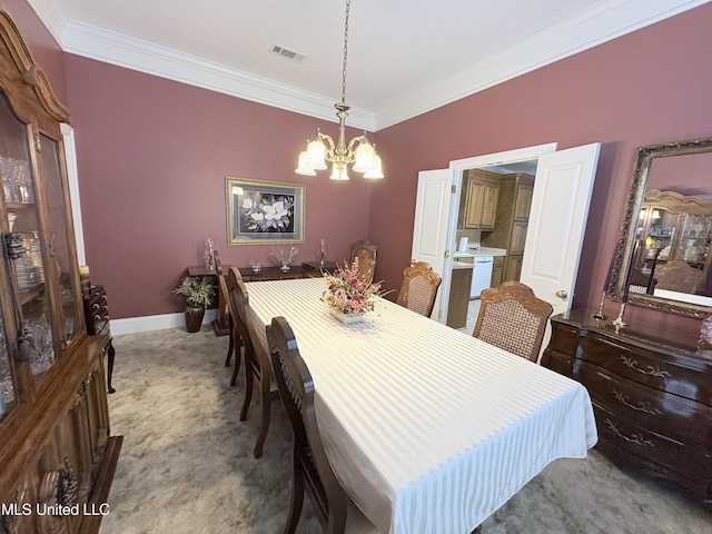 carpeted dining space featuring baseboards, visible vents, a chandelier, and ornamental molding