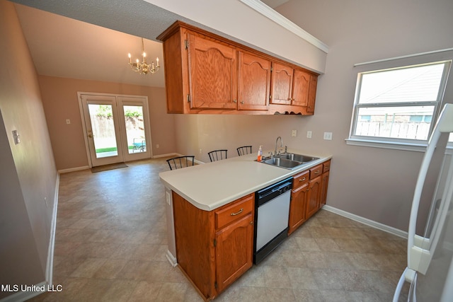 kitchen featuring a sink, brown cabinetry, a notable chandelier, plenty of natural light, and white appliances