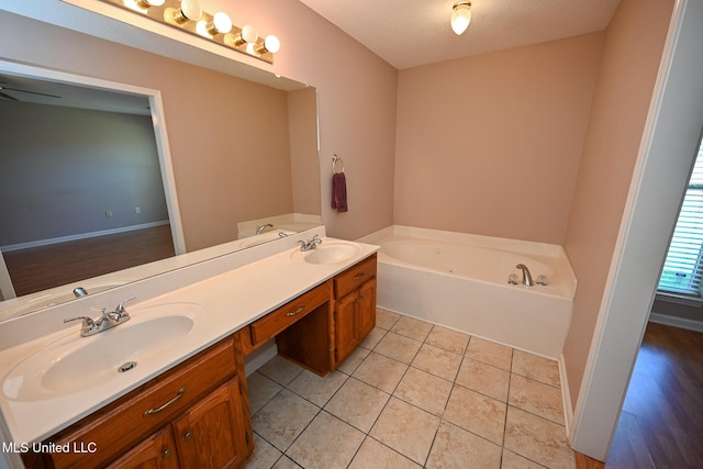 bathroom featuring double vanity, a bath, tile patterned flooring, and a sink