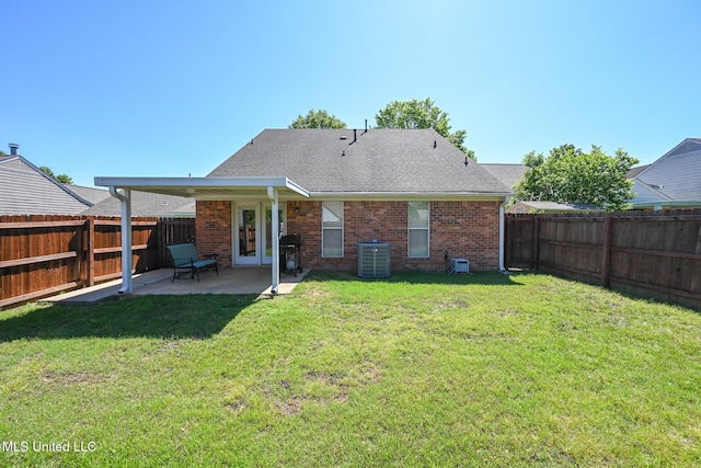 back of property with a fenced backyard, a patio area, central air condition unit, and brick siding