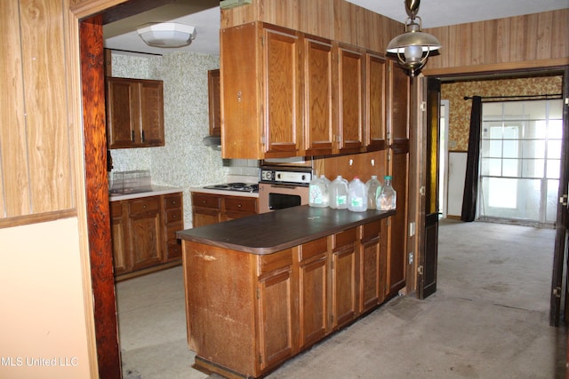 7000 Melrose Dr, Biloxi, MS 39532 - kitchen featuring oven, cooktop, brown cabinets, and light colored carpet