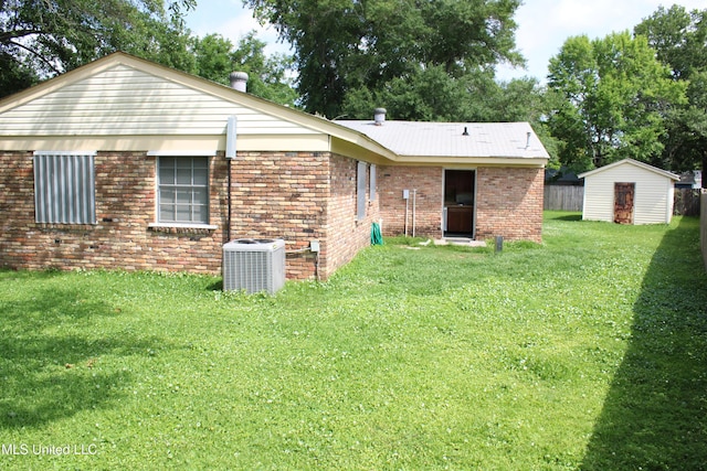 7000 Melrose Dr, Biloxi, MS 39532 - rear view of house featuring central AC, a lawn, brick siding, and an outdoor structure