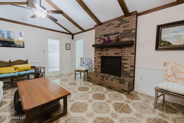 living room featuring a brick fireplace, a ceiling fan, wainscoting, and lofted ceiling with beams