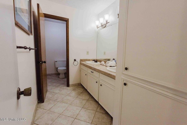 full bathroom featuring double vanity, toilet, a sink, and tile patterned flooring