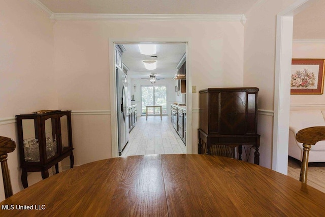 dining room featuring a ceiling fan, ornamental molding, and light wood-type flooring