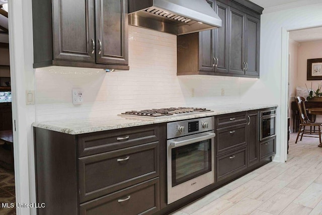 kitchen with stainless steel appliances, custom exhaust hood, ornamental molding, and tasteful backsplash