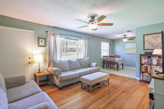 2709 Burma Dr, Pearl, MS 39208 - living room featuring light wood-style floors, a ceiling fan, and a textured ceiling