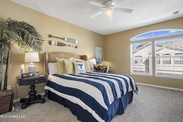 bedroom with ceiling fan, light colored carpet, and a textured ceiling