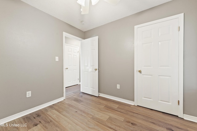 unfurnished bedroom with baseboards, ceiling fan, and light wood finished floors