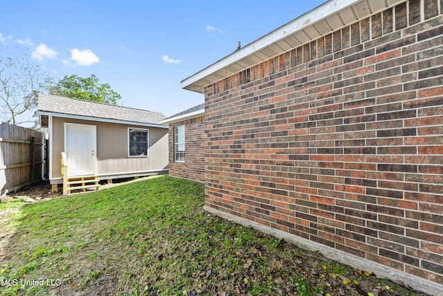 view of yard featuring entry steps, an outdoor structure, and fence