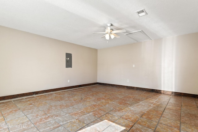 spare room featuring visible vents, a ceiling fan, electric panel, baseboards, and attic access