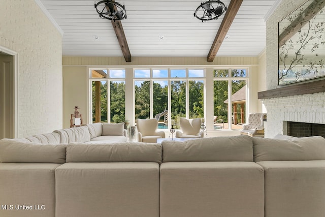 living room with beam ceiling, a brick fireplace, and wooden ceiling