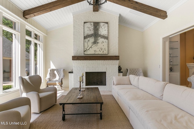 living room with a healthy amount of sunlight, lofted ceiling with beams, and a brick fireplace