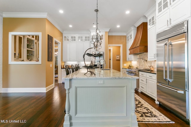 kitchen with premium range hood, white cabinetry, light stone countertops, dark hardwood / wood-style floors, and stainless steel appliances