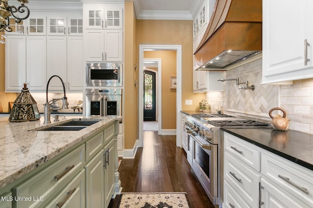 kitchen featuring dark hardwood / wood-style floors, custom range hood, ornamental molding, white cabinetry, and appliances with stainless steel finishes