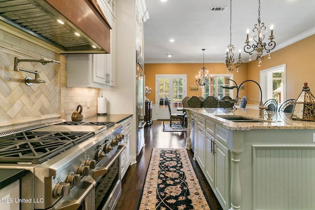 kitchen with white cabinets, a healthy amount of sunlight, high end range, and dark hardwood / wood-style flooring