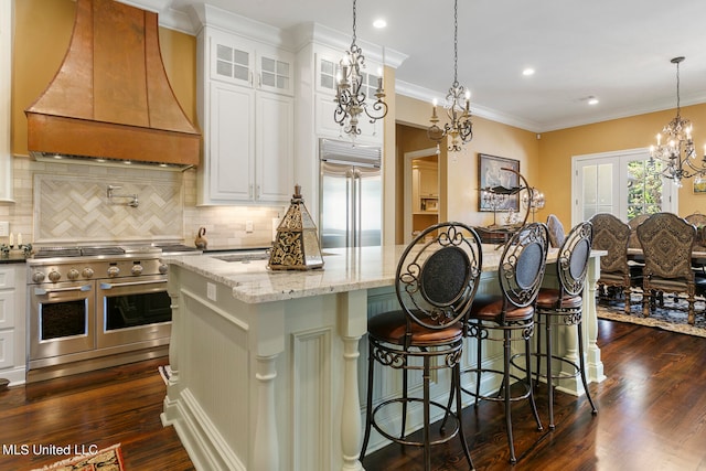 kitchen with custom exhaust hood, white cabinetry, a kitchen island, and high end appliances