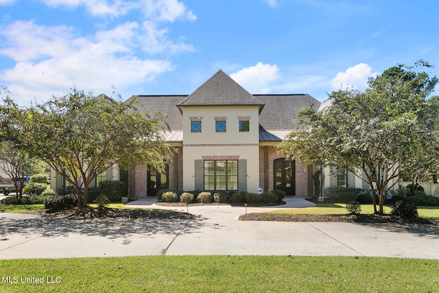 french country home featuring a front yard