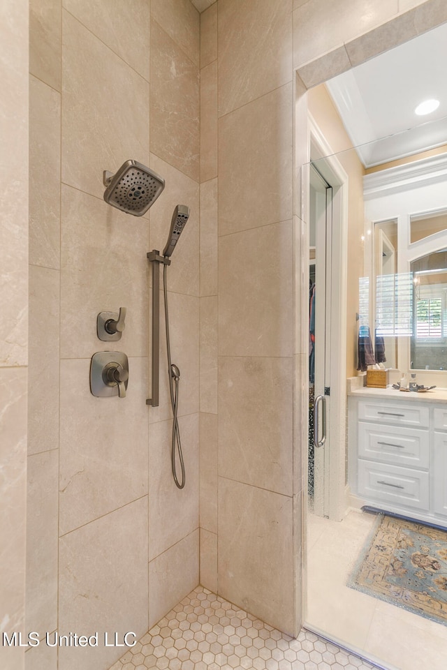 bathroom featuring vanity, tiled shower, and tile patterned flooring