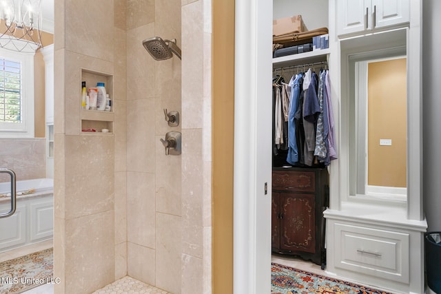 bathroom featuring a chandelier, tile patterned floors, and tiled shower