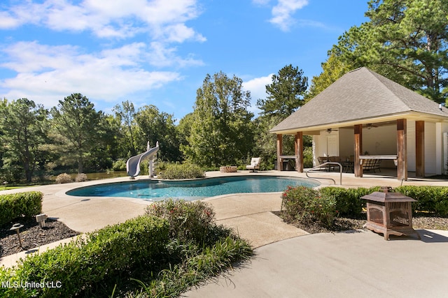 view of swimming pool with a patio area, ceiling fan, and a water slide