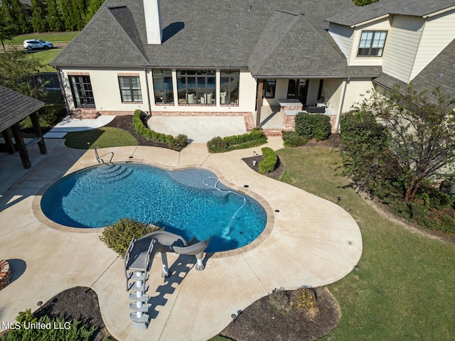 view of swimming pool featuring a yard and a patio area