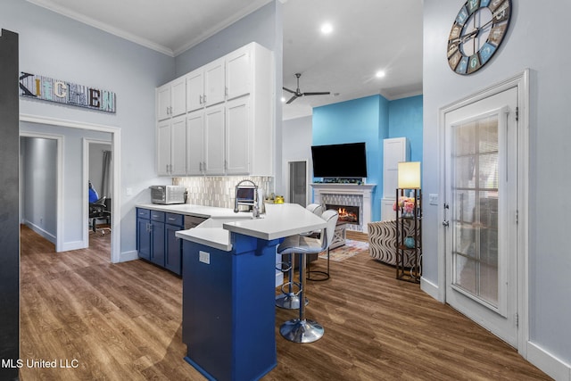 527 Pelahatchie Shore Dr, Brandon, MS 39047 - kitchen featuring a ceiling fan, a breakfast bar, white cabinets, a peninsula, and dark wood-style flooring
