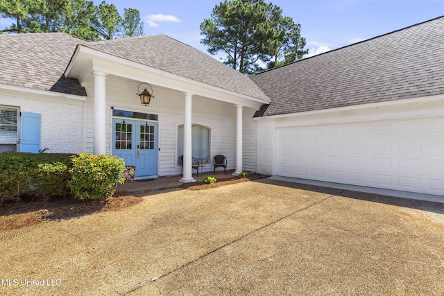527 Pelahatchie Shore Dr, Brandon, MS 39047 - view of exterior entry with roof with shingles, concrete driveway, an attached garage, and brick siding