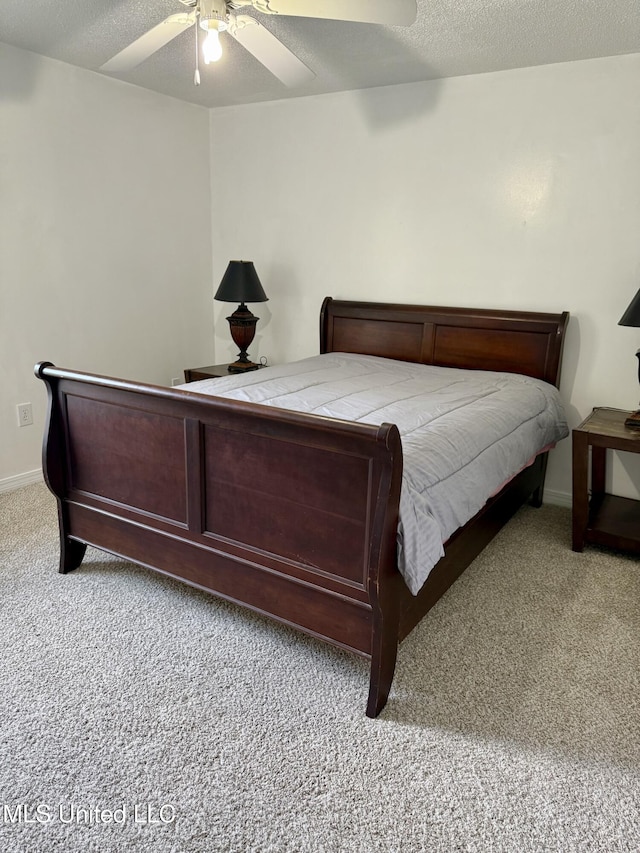 carpeted bedroom featuring baseboards, ceiling fan, and a textured ceiling