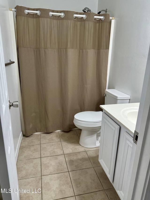 bathroom featuring vanity, a shower with shower curtain, tile patterned floors, and toilet