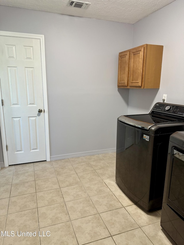 washroom with visible vents, a textured ceiling, cabinet space, independent washer and dryer, and light tile patterned floors