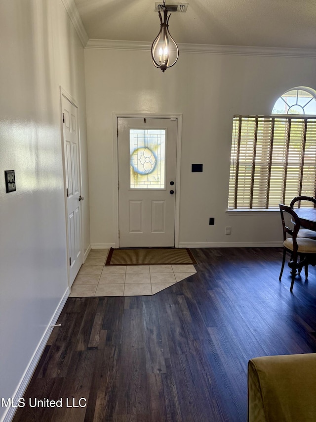 entryway featuring baseboards, ornamental molding, and wood finished floors