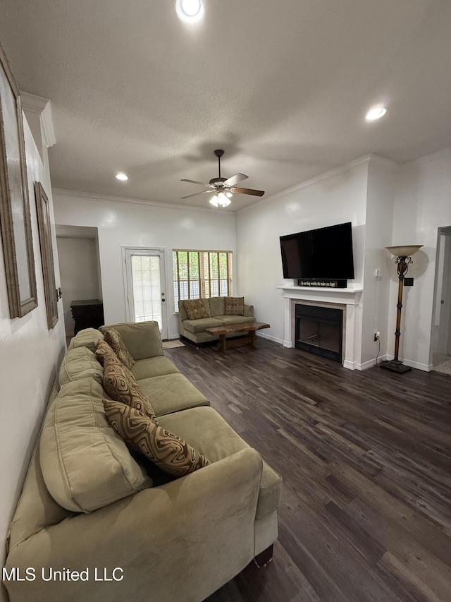 living area with crown molding, a ceiling fan, and dark wood-type flooring