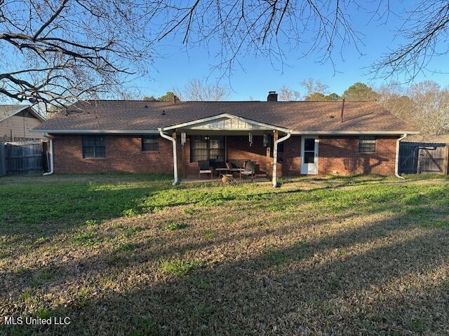 back of property featuring a patio, a yard, fence, and brick siding