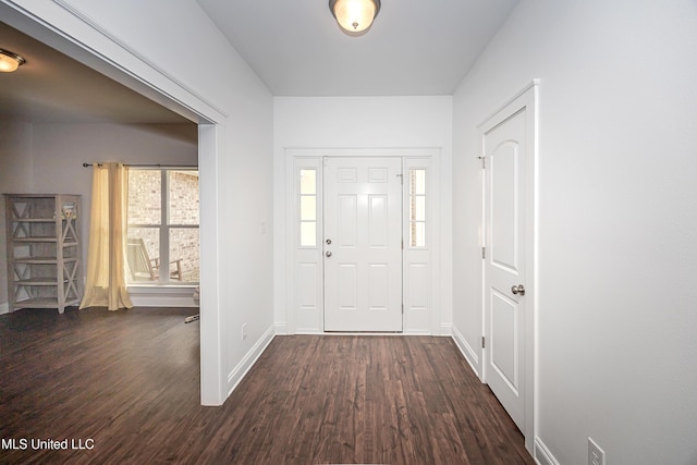 foyer entrance with dark wood-style floors and baseboards