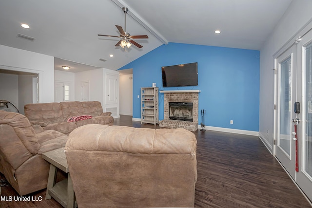 living area featuring a ceiling fan, visible vents, vaulted ceiling with beams, a fireplace, and dark wood-type flooring