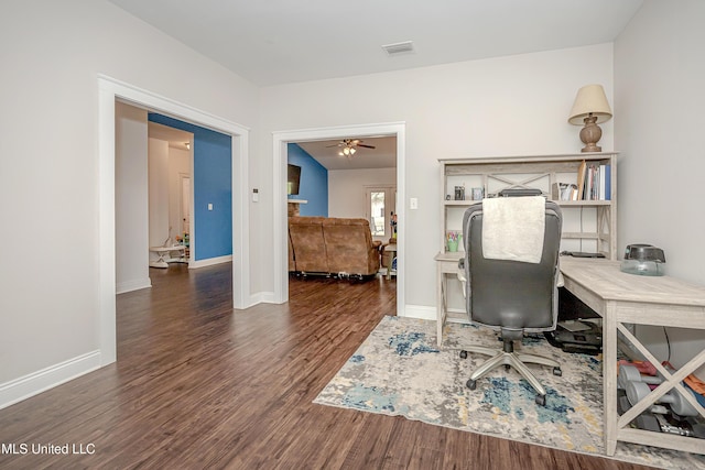 office with visible vents, a ceiling fan, baseboards, and wood finished floors