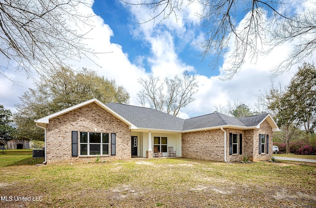 ranch-style house featuring a front lawn, central air condition unit, and brick siding