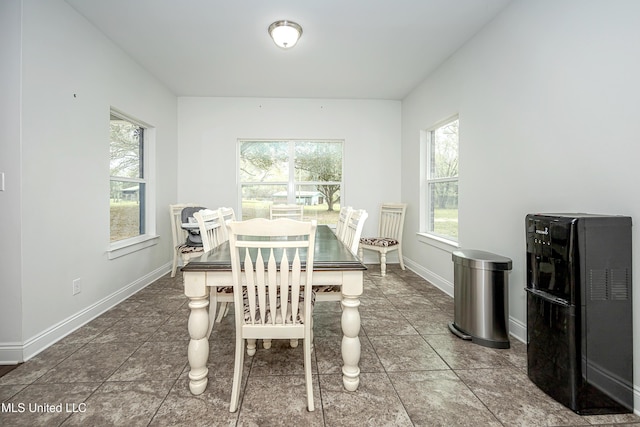 tiled dining room featuring baseboards