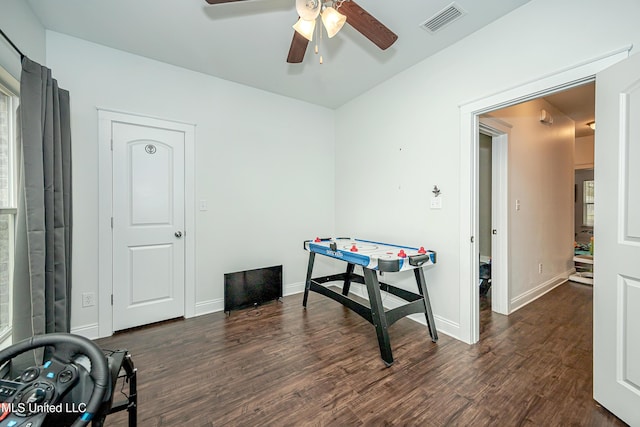 rec room featuring visible vents, baseboards, dark wood-style flooring, and a ceiling fan