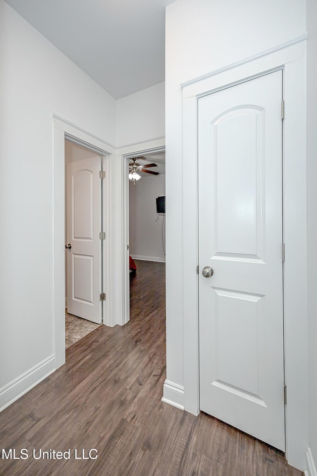 corridor featuring wood finished floors and baseboards