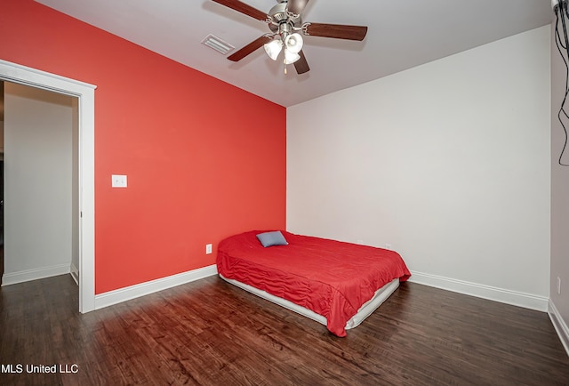 bedroom with ceiling fan, wood finished floors, visible vents, and baseboards