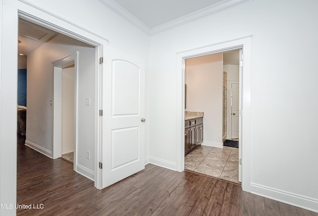 hallway with crown molding, baseboards, and dark wood-style flooring