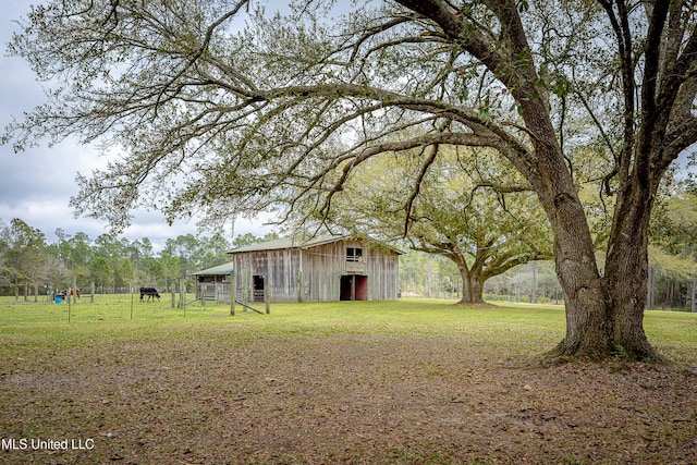 view of yard featuring an outdoor structure and fence