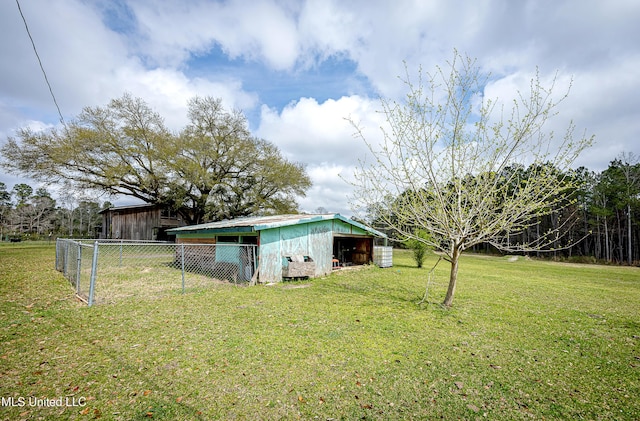 view of yard featuring an outdoor structure, a pole building, and fence