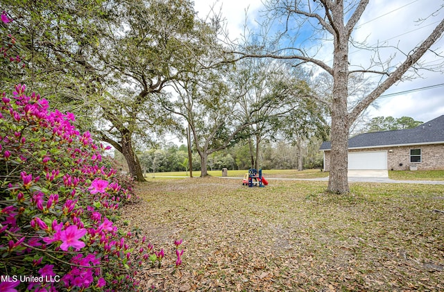 view of yard featuring an attached garage and driveway