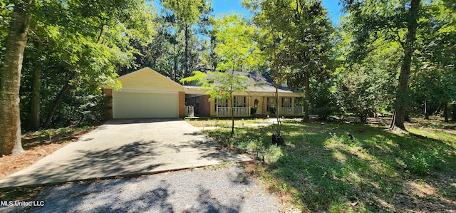 ranch-style home featuring a garage, covered porch, and a front lawn