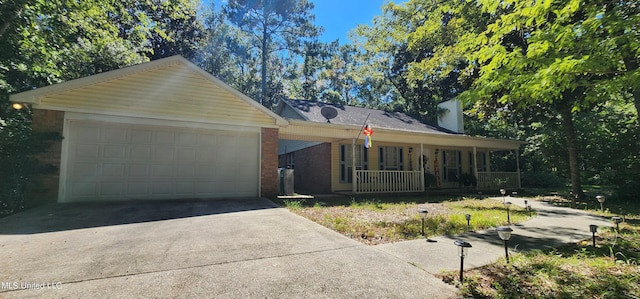 ranch-style home featuring covered porch and a garage